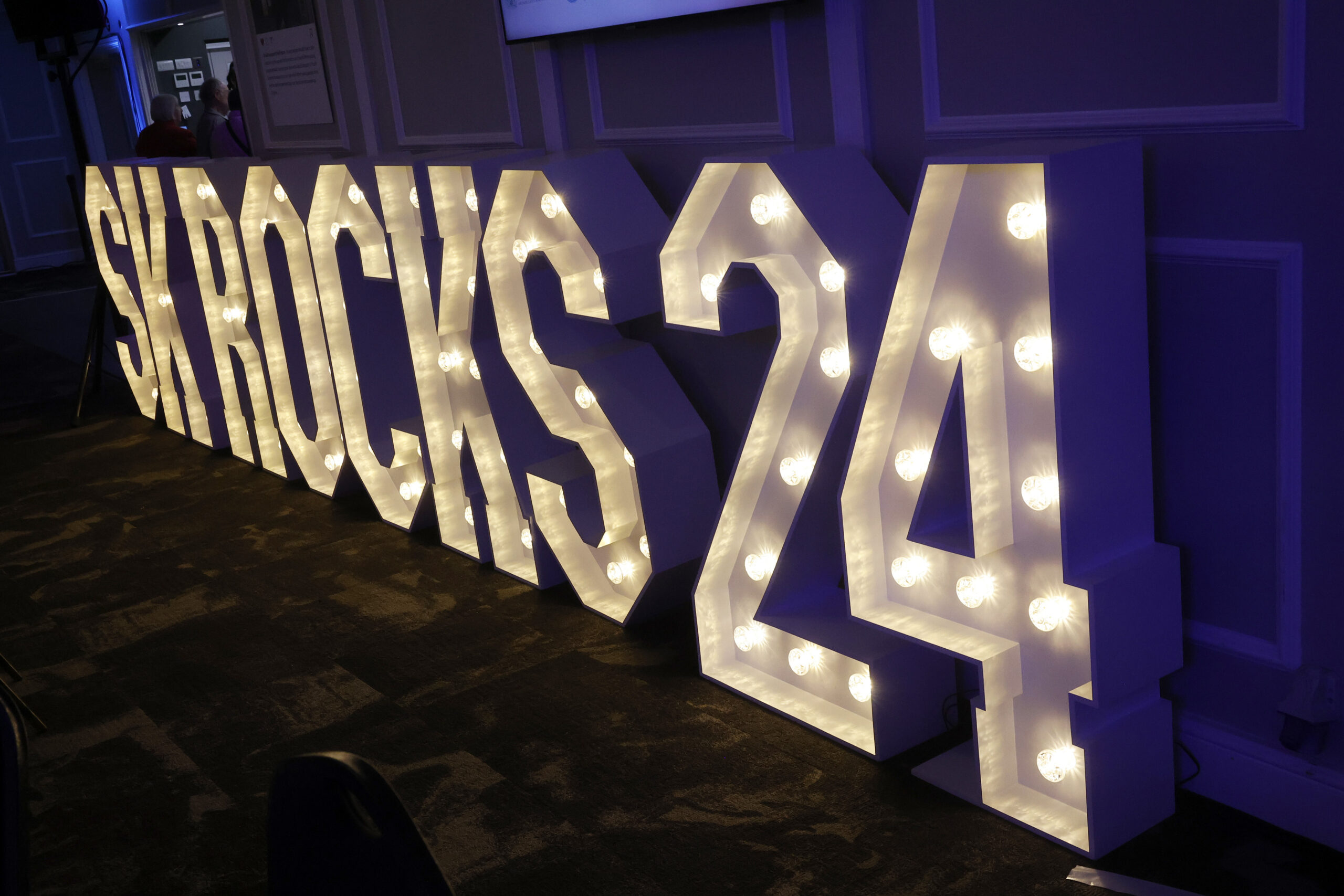 Letters spelling 'SK Rocks' lit up in a dark room